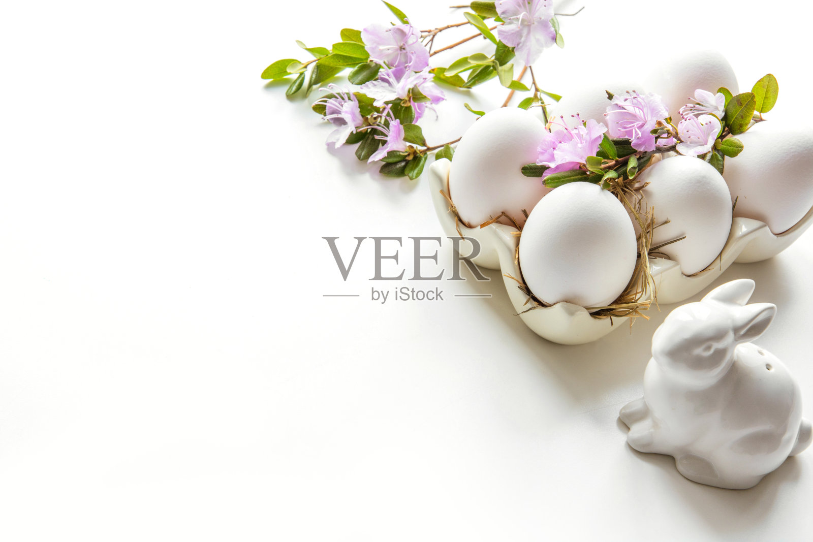 复活节。白兔子和带花的蛋。准备颜色。照片摄影图片