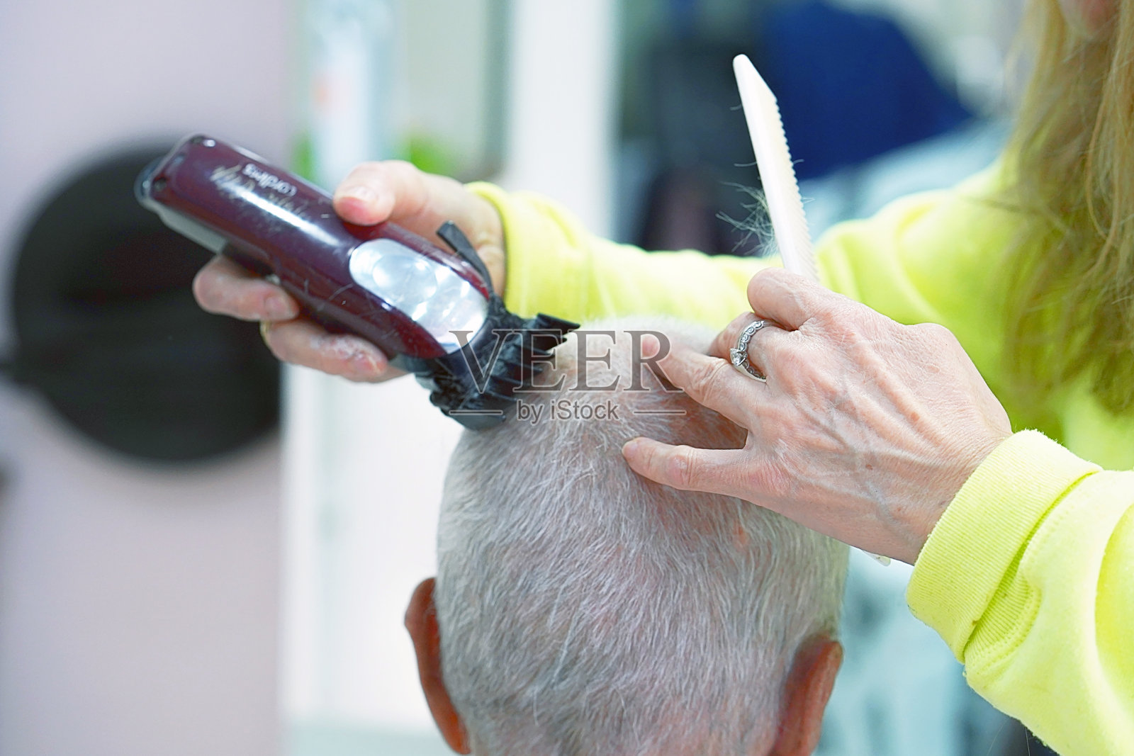 一位上了年纪的妇女理发师正在修剪一位老人的手照片摄影图片