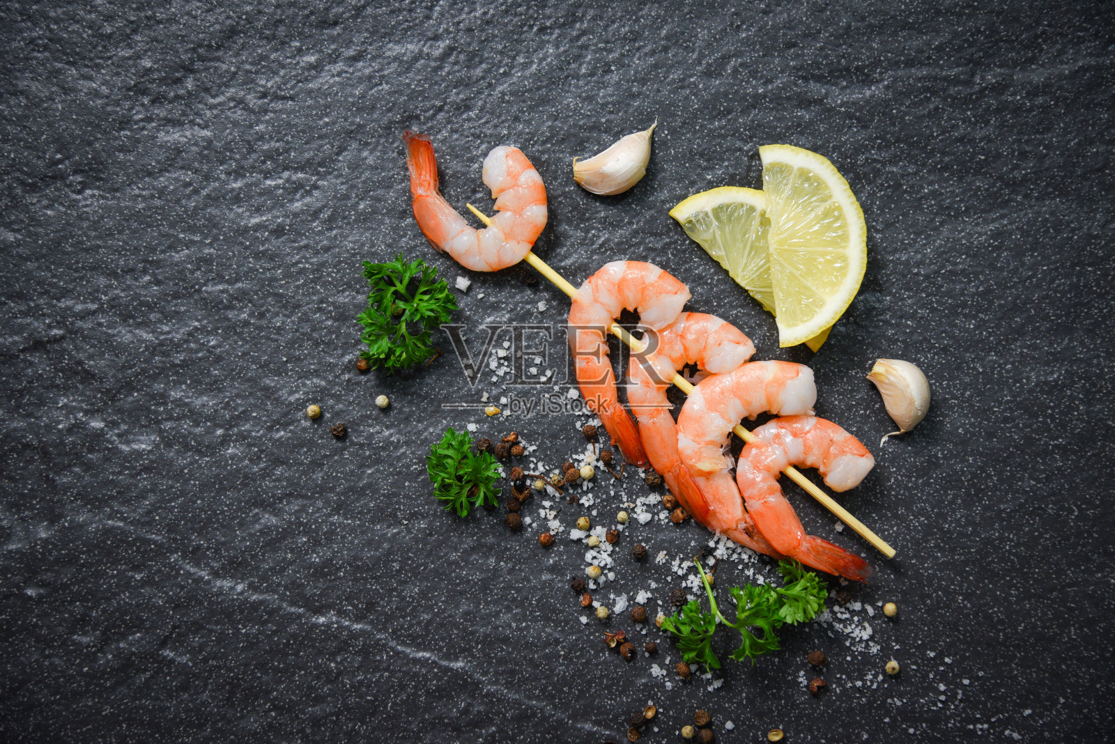 虾，对虾串，海鲜与香草和香料煮在黑暗的背景照片摄影图片