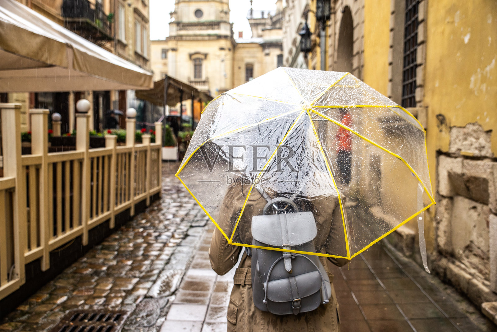 带着透明伞在雨中行走的女人照片摄影图片