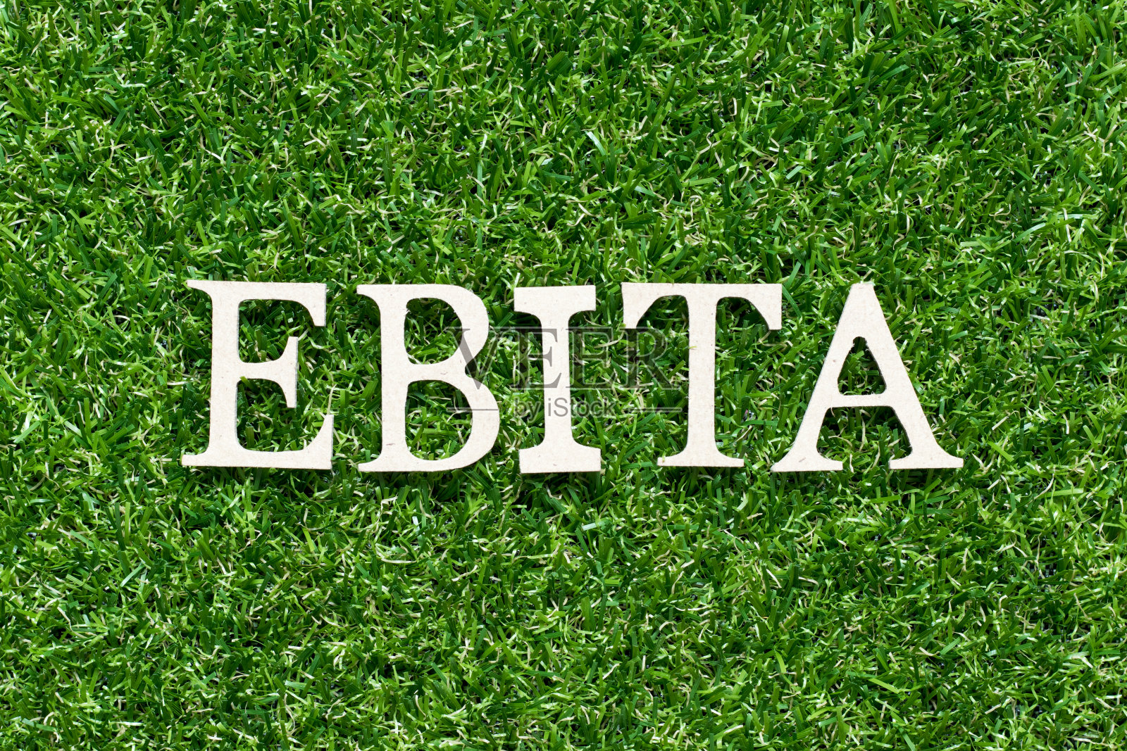 木字母字母在词EBITA(缩写前收益的利息，税项和摊销)人工绿草背景照片摄影图片