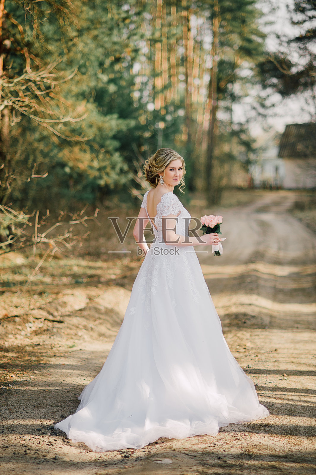 美丽的新娘肖像与新娘花束摆姿势在她的婚礼当天照片摄影图片