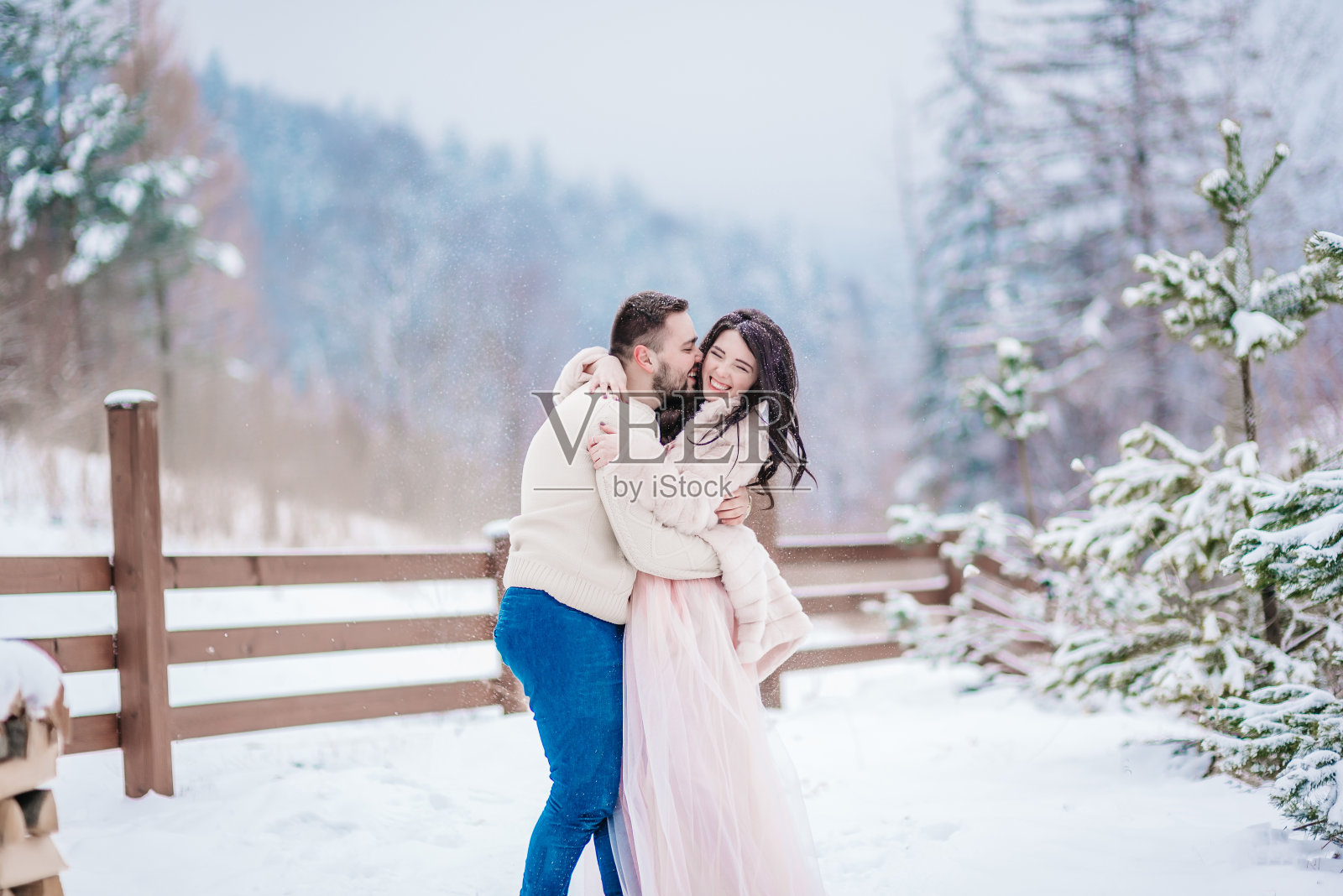 一对年轻夫妇在雪山里散步照片摄影图片