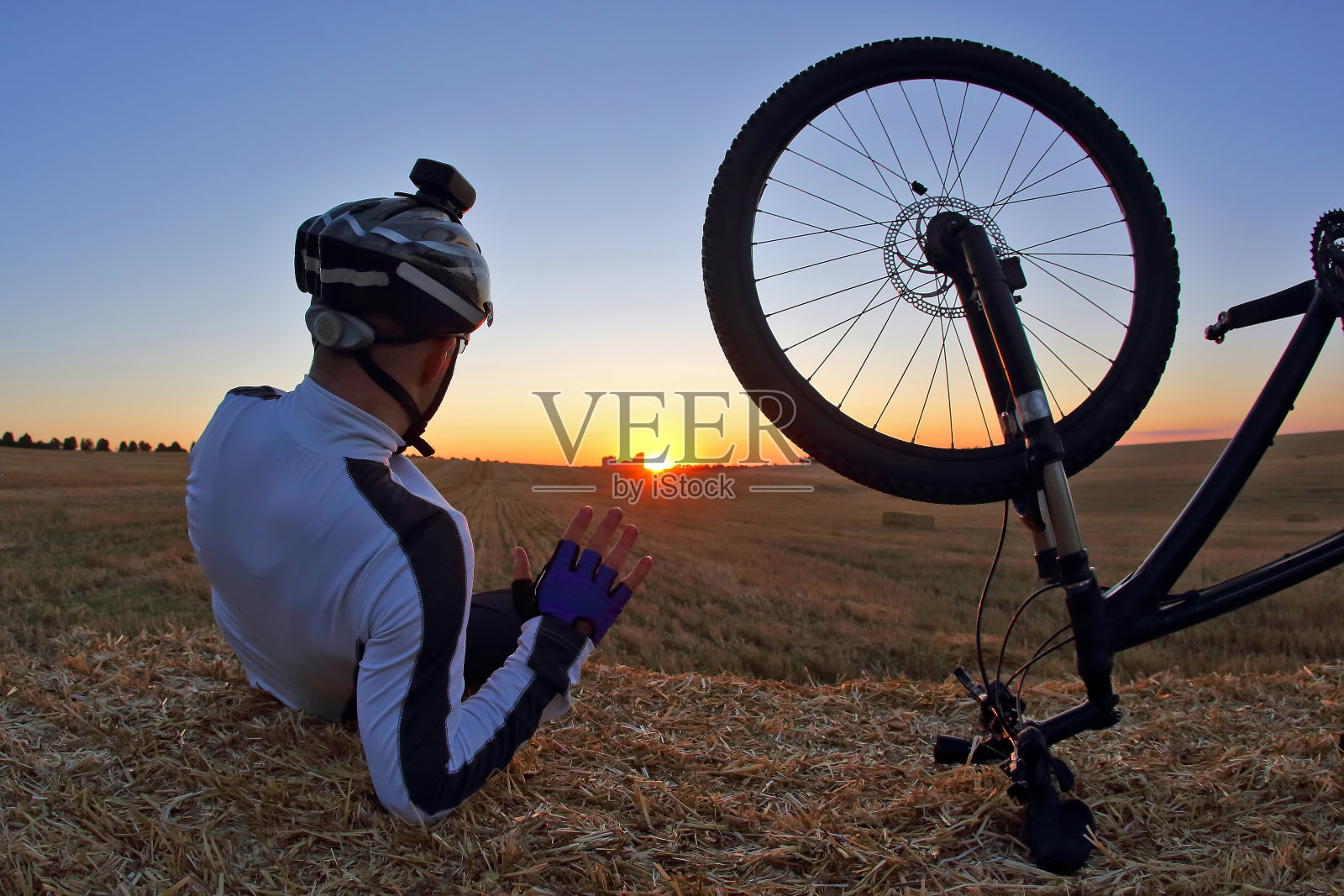 骑着自行车休息的人看着日落照片摄影图片