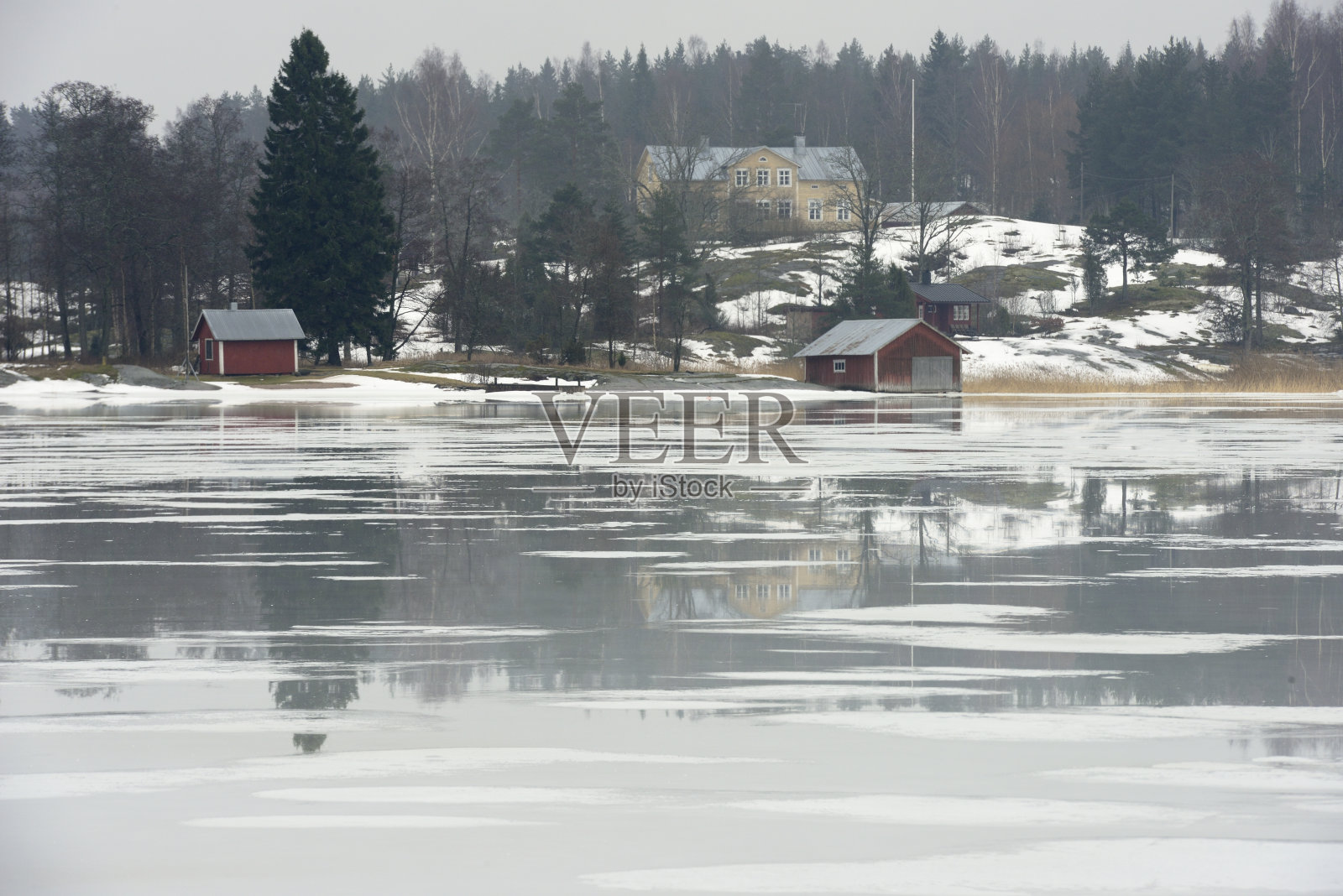 芬兰的一个村庄，岸边有一个结冰的湖，风景优美照片摄影图片