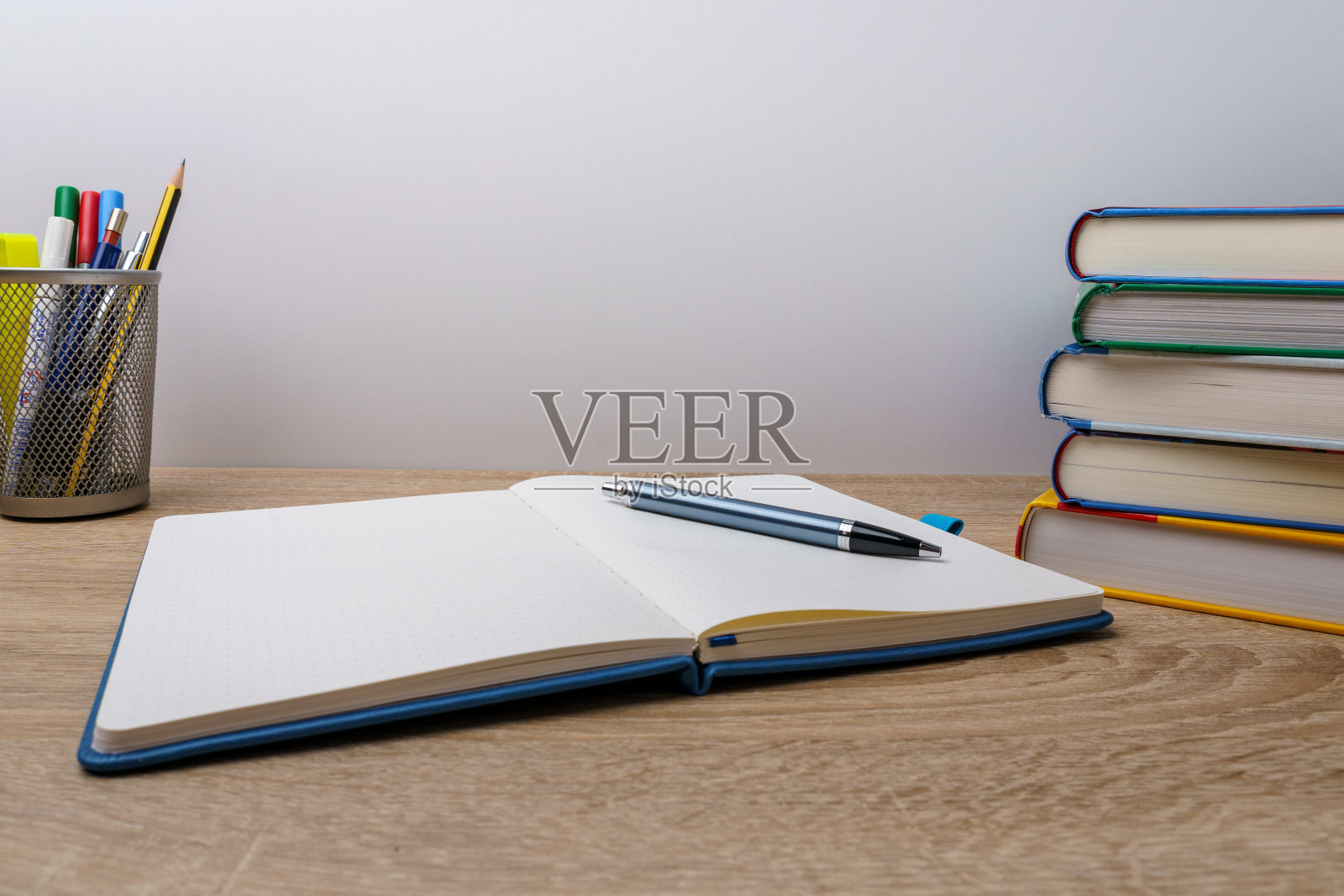 笔记本与钢笔，书和笔在一个木制桌子前面的白色背景照片摄影图片