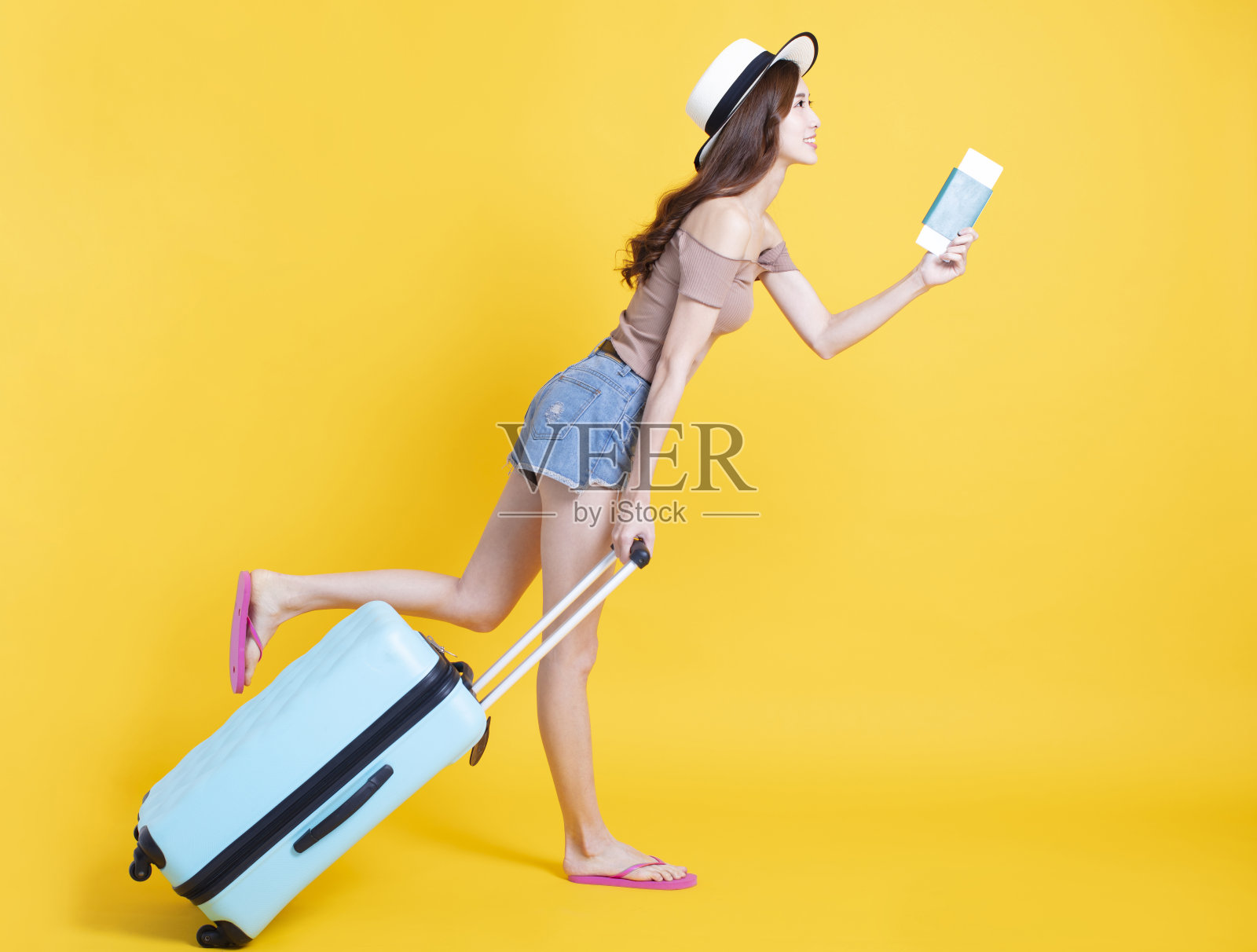 快乐的女游客戴着夏天的帽子，带着护照和手提箱照片摄影图片