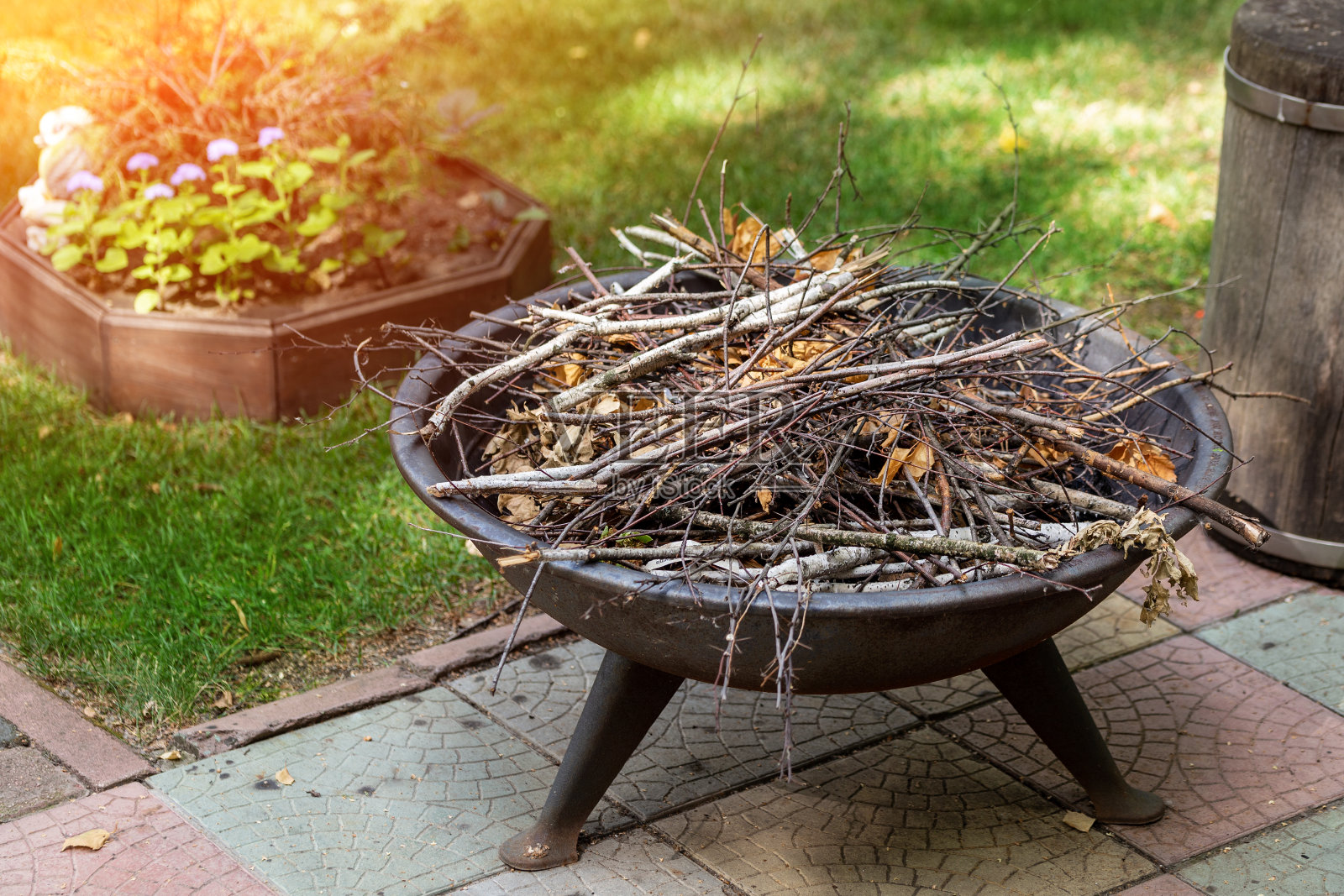 夏季别墅后院的便携式铁壁炉与干灌木。篝火为晚上的篝火故事做准备照片摄影图片