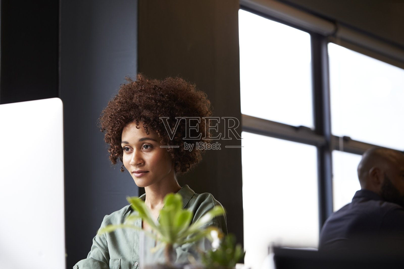 千禧黑人女性创意坐在办公桌上使用电脑，近距离照片摄影图片