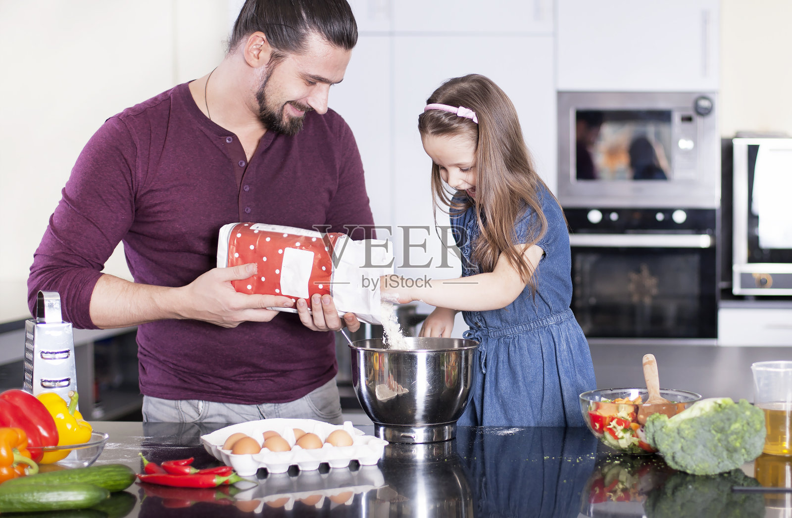 父亲和女儿一起在厨房做饭。烹饪课的概念照片摄影图片