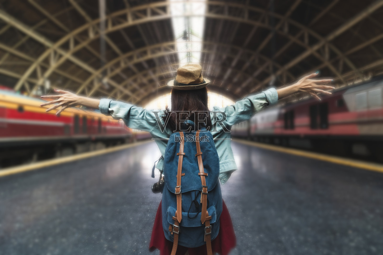 轻松的年轻亚洲背包女站在火车站。旅行的生活方式的概念。照片摄影图片