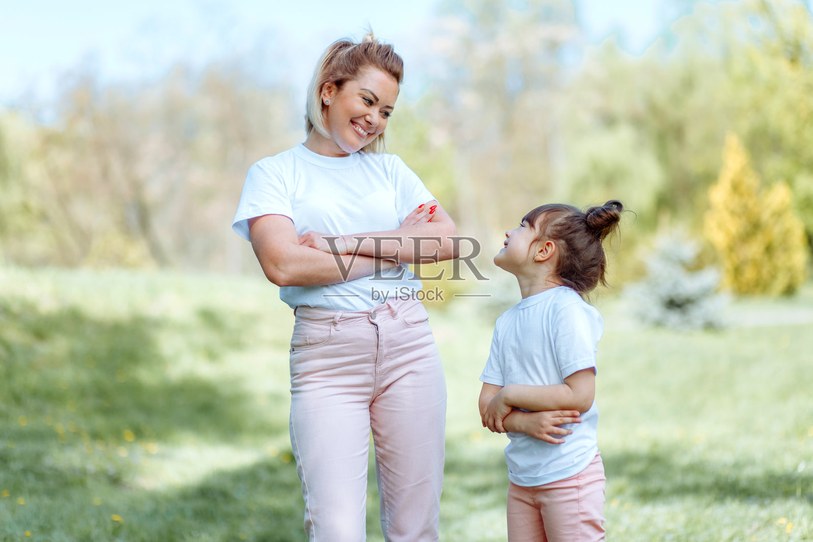母亲和女儿在公园的肖像。照片摄影图片