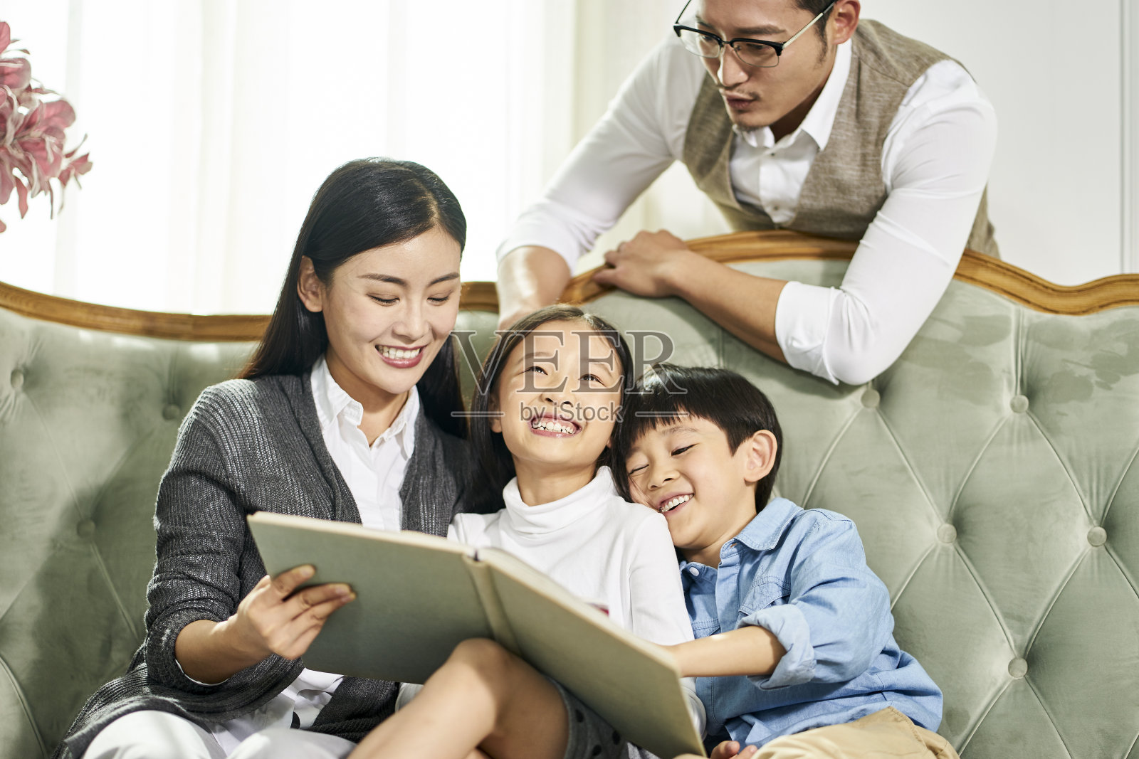 亚洲父母和孩子一起在家看书照片摄影图片