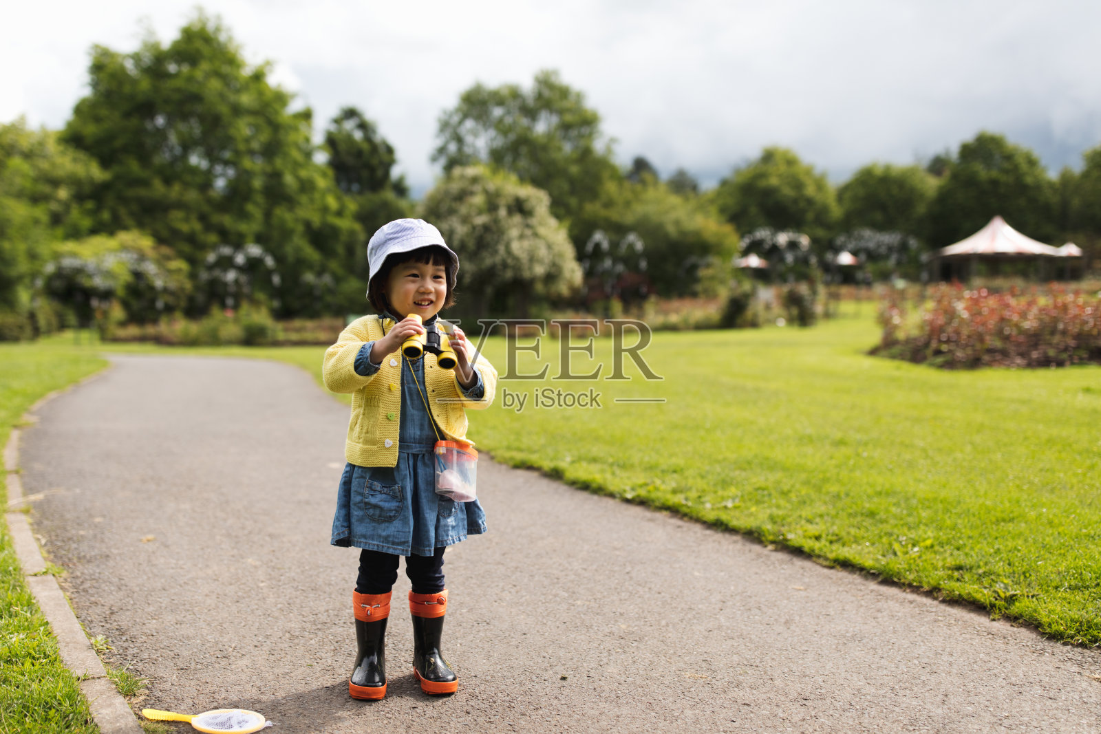蹒跚学步的小女孩在春天的公园里玩耍照片摄影图片