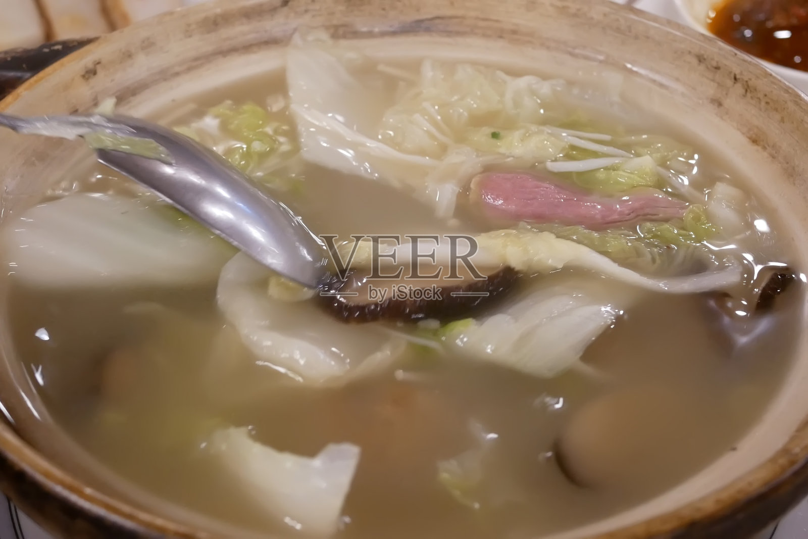 中餐馆里人们在碗里搅拌汤的动作照片摄影图片