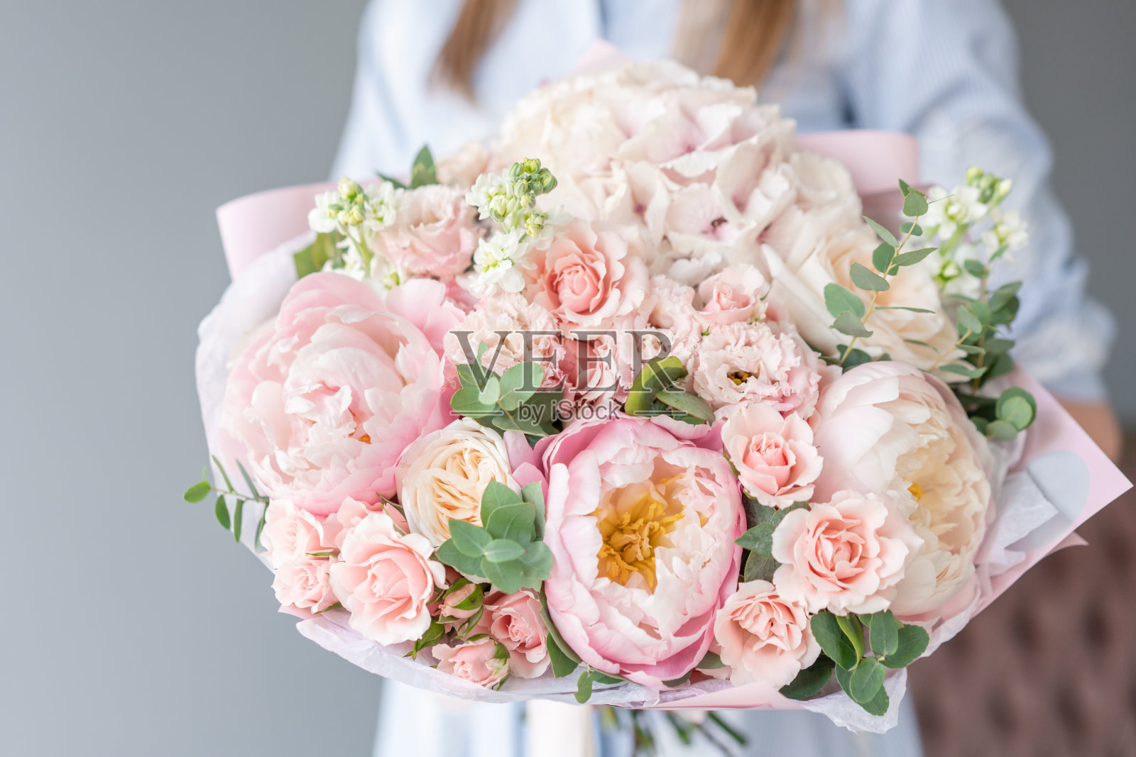 女人手里拿着两束美丽的混合鲜花。花店概念。漂亮的新鲜花束。鲜花交付照片摄影图片