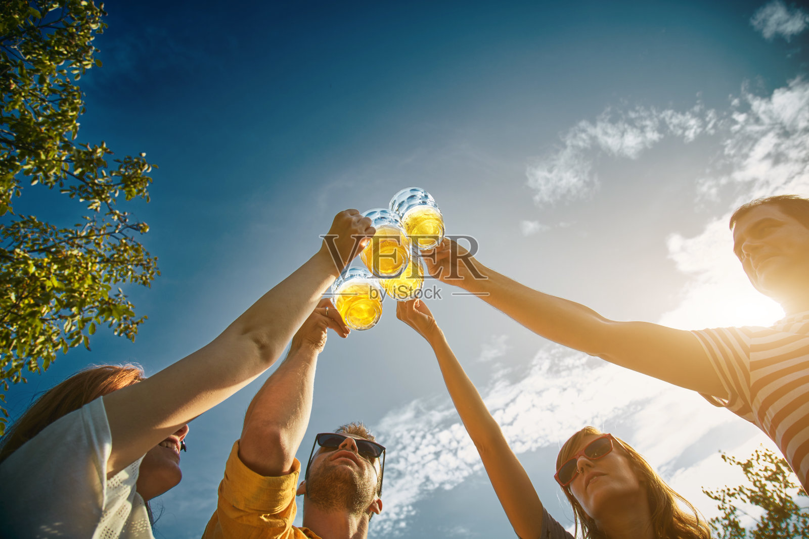 一群年轻人在户外享受和欢呼啤酒。照片摄影图片