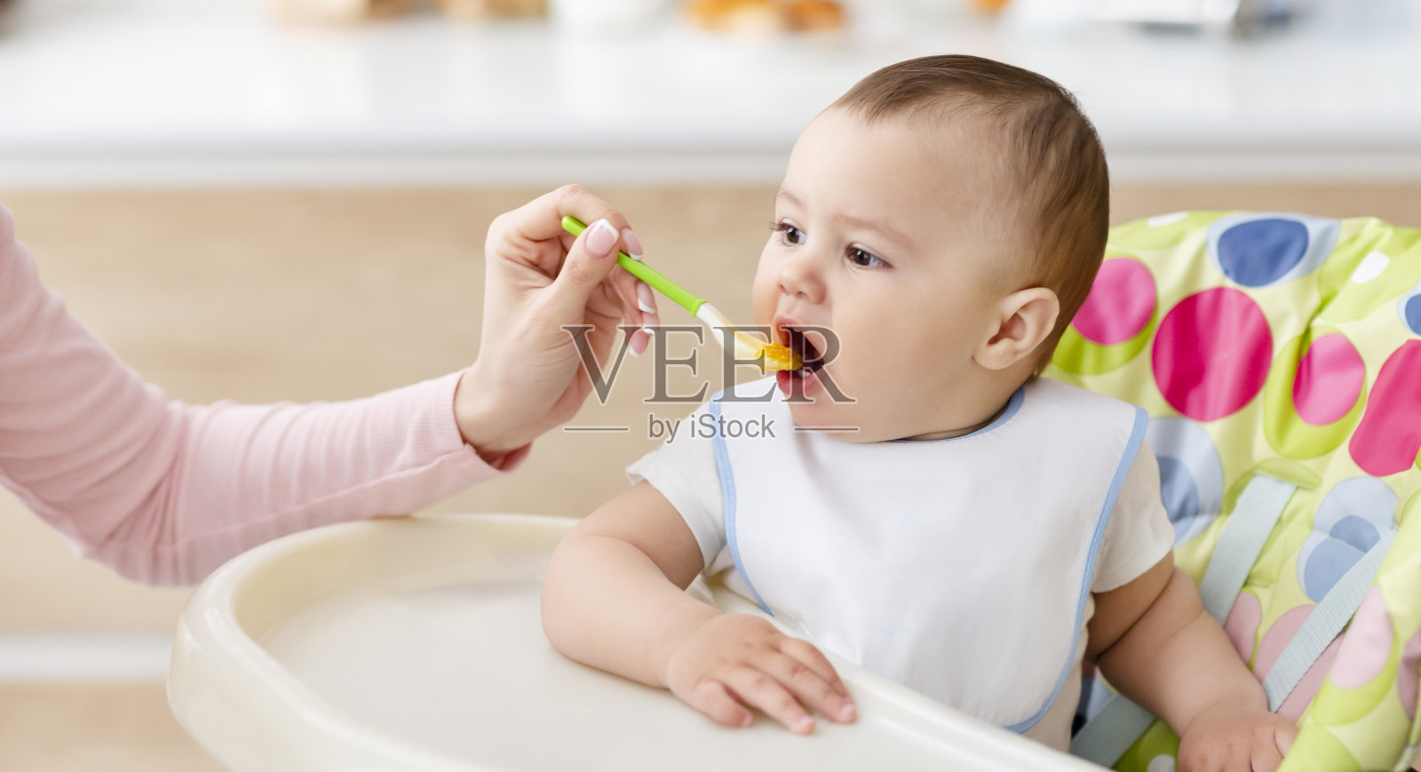 妈妈用新鲜的有机婴儿食品喂她的孩子照片摄影图片