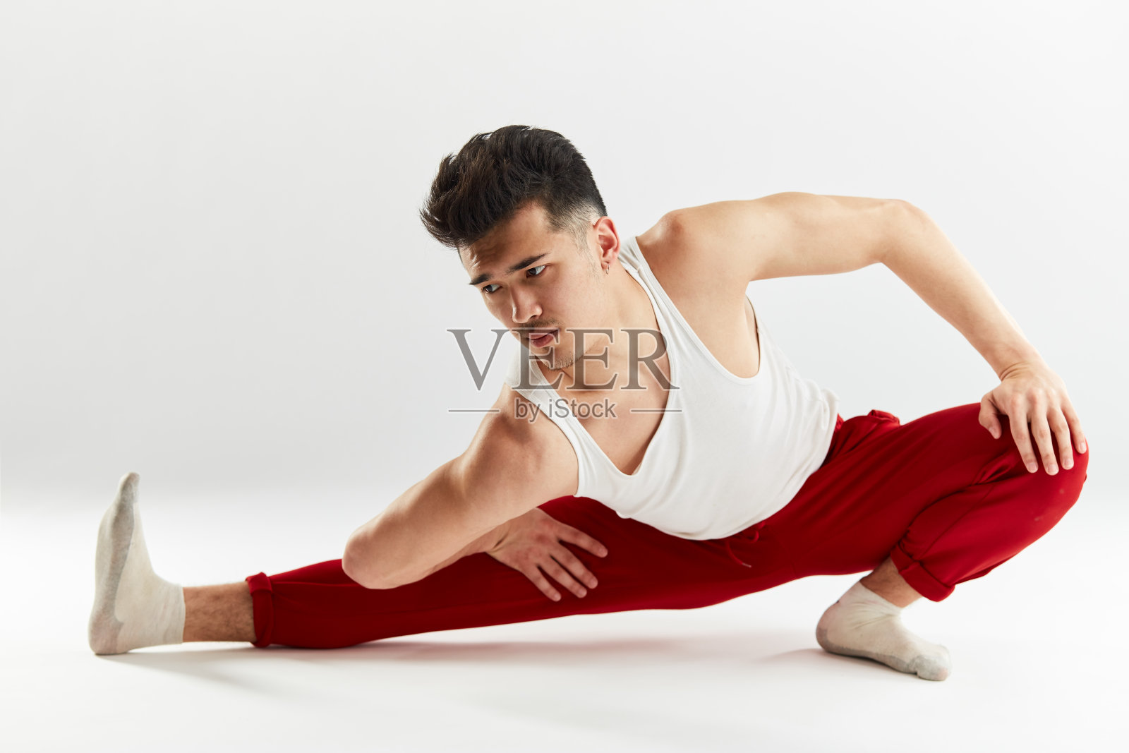 亚洲英俊的舞者伸展他的腿前bboying。照片摄影图片