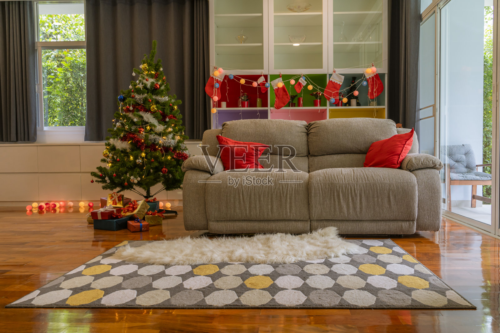 室内装饰以圣诞为主题，配有沙发、圣诞树和礼品盒照片摄影图片