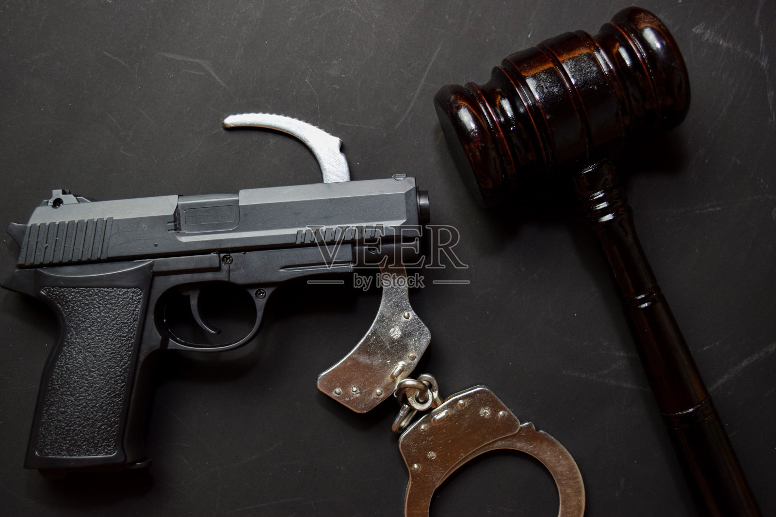 枪，手铐和黑色木槌孤立在黑色背景。正义与法律观念照片摄影图片