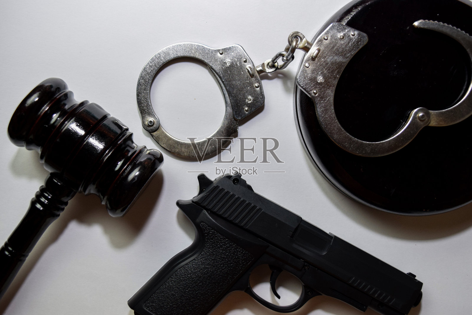 枪，手铐和黑色木槌孤立在白色背景。正义与法律观念照片摄影图片