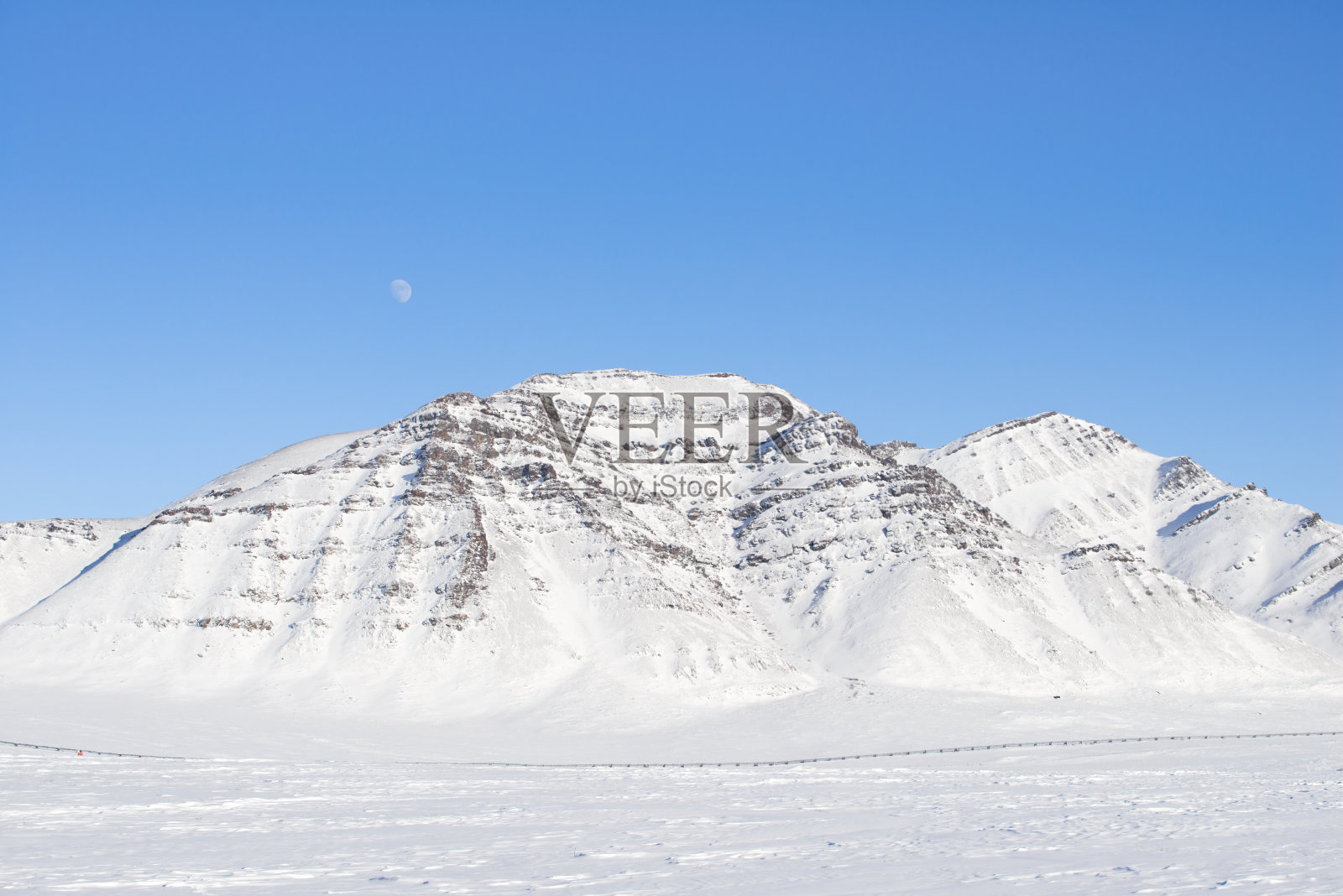 山上覆盖着积雪，天上挂着月亮照片摄影图片
