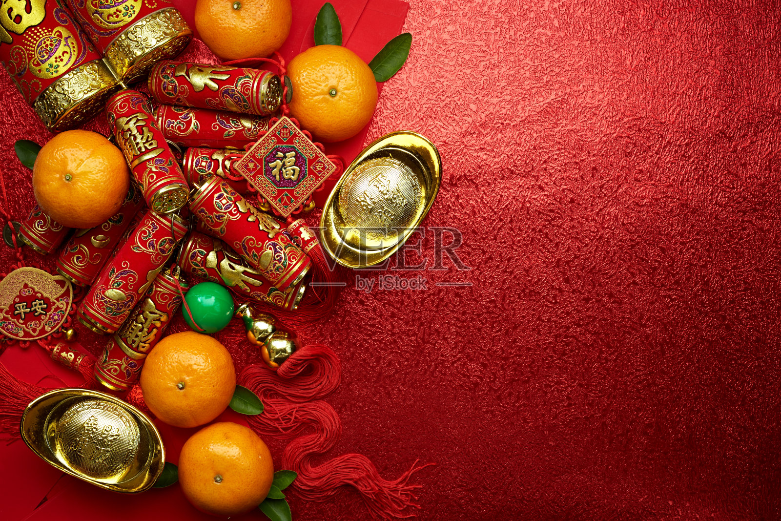 中国的硬币或中国结和中国金元宝和传统的中国结(外国文字意味着祝福)和红色的信封和装饰与新鲜的橙子在红色的背景照片摄影图片