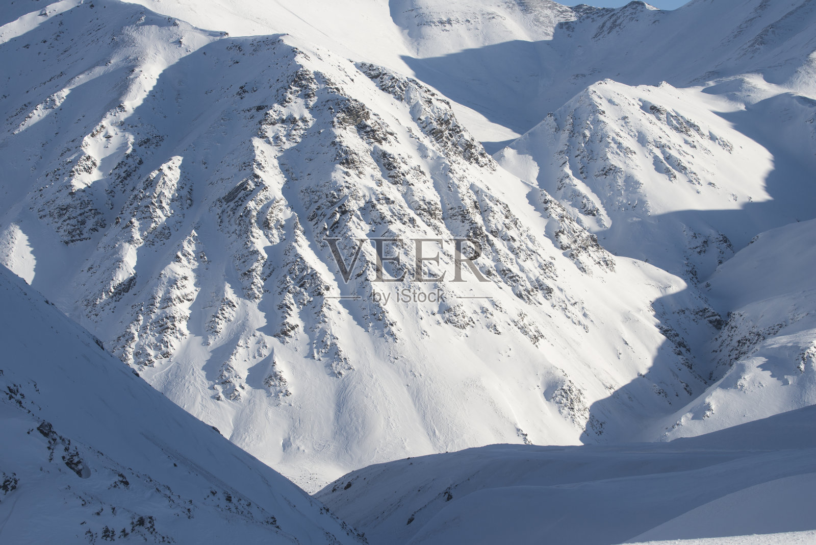 山上覆盖着白雪，还有湛蓝的天空照片摄影图片
