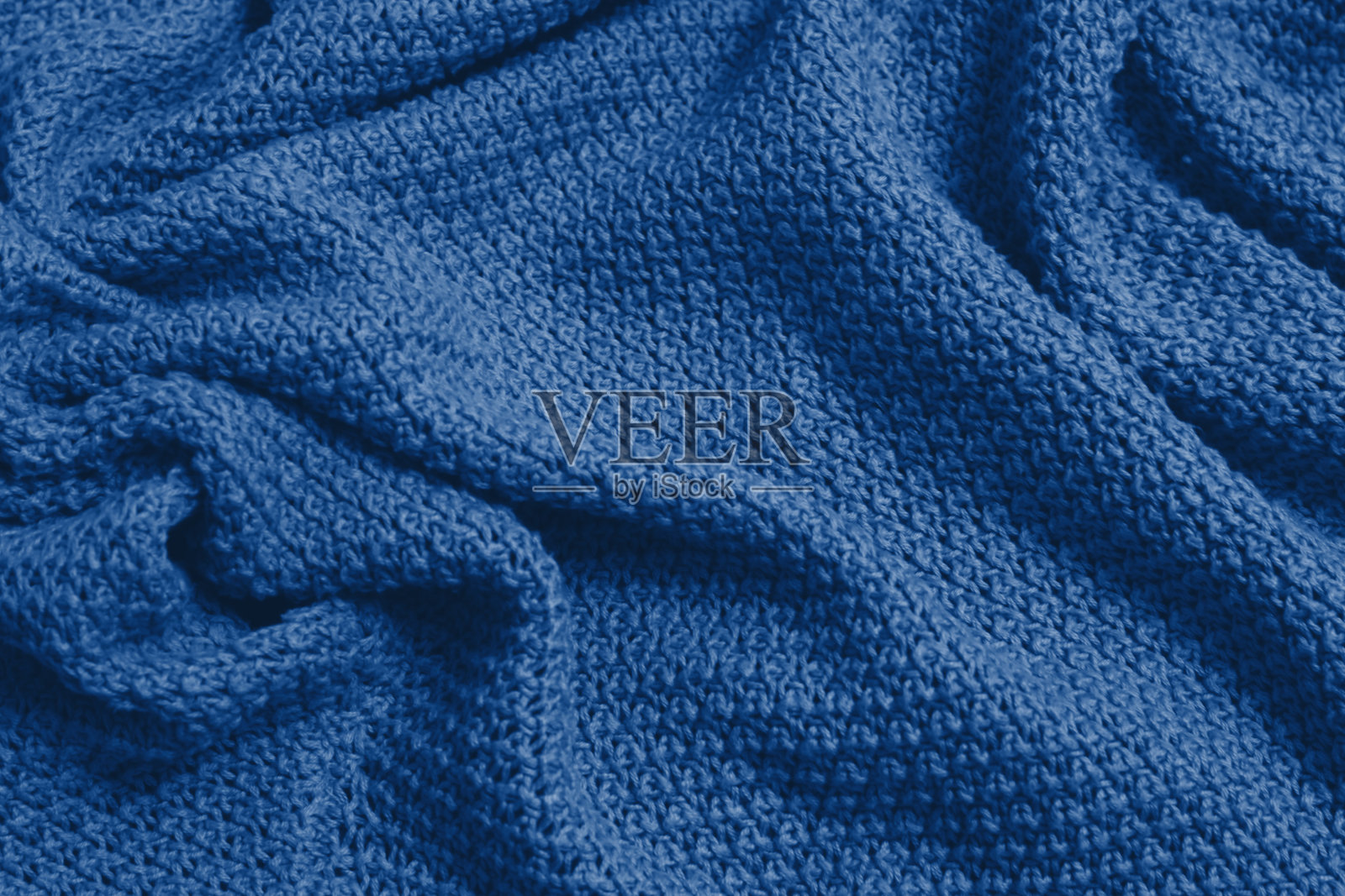 经典的蓝色单色纹理针织物。蓝色针织运动衫作为纺织背景。经典的蓝色背景。羊毛针织质地。2020年时尚的颜色。照片摄影图片