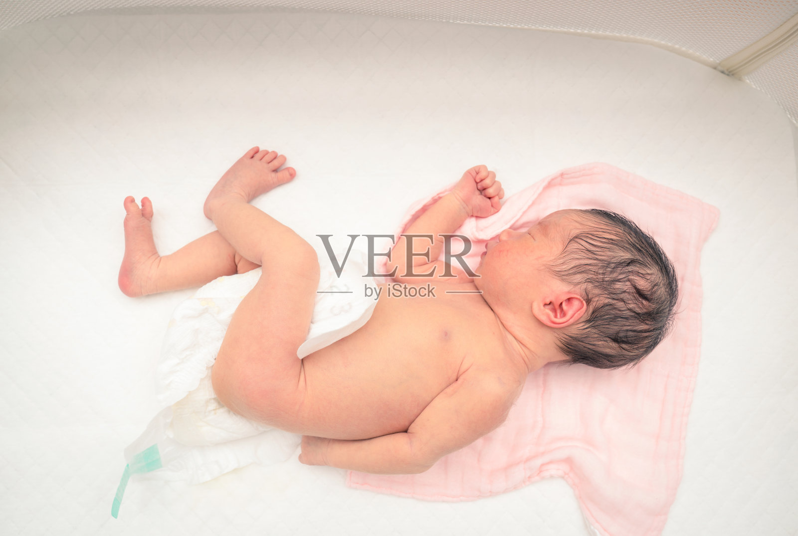 在白色的婴儿床里熟睡的新生婴儿照片摄影图片