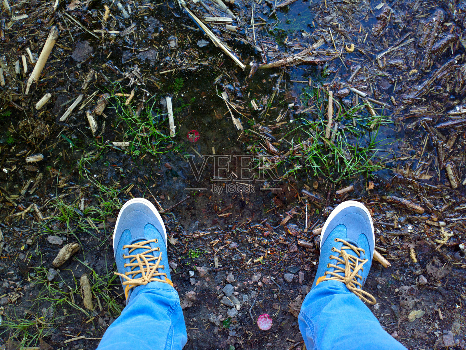 脚放在脏水附近的地上。照片摄影图片