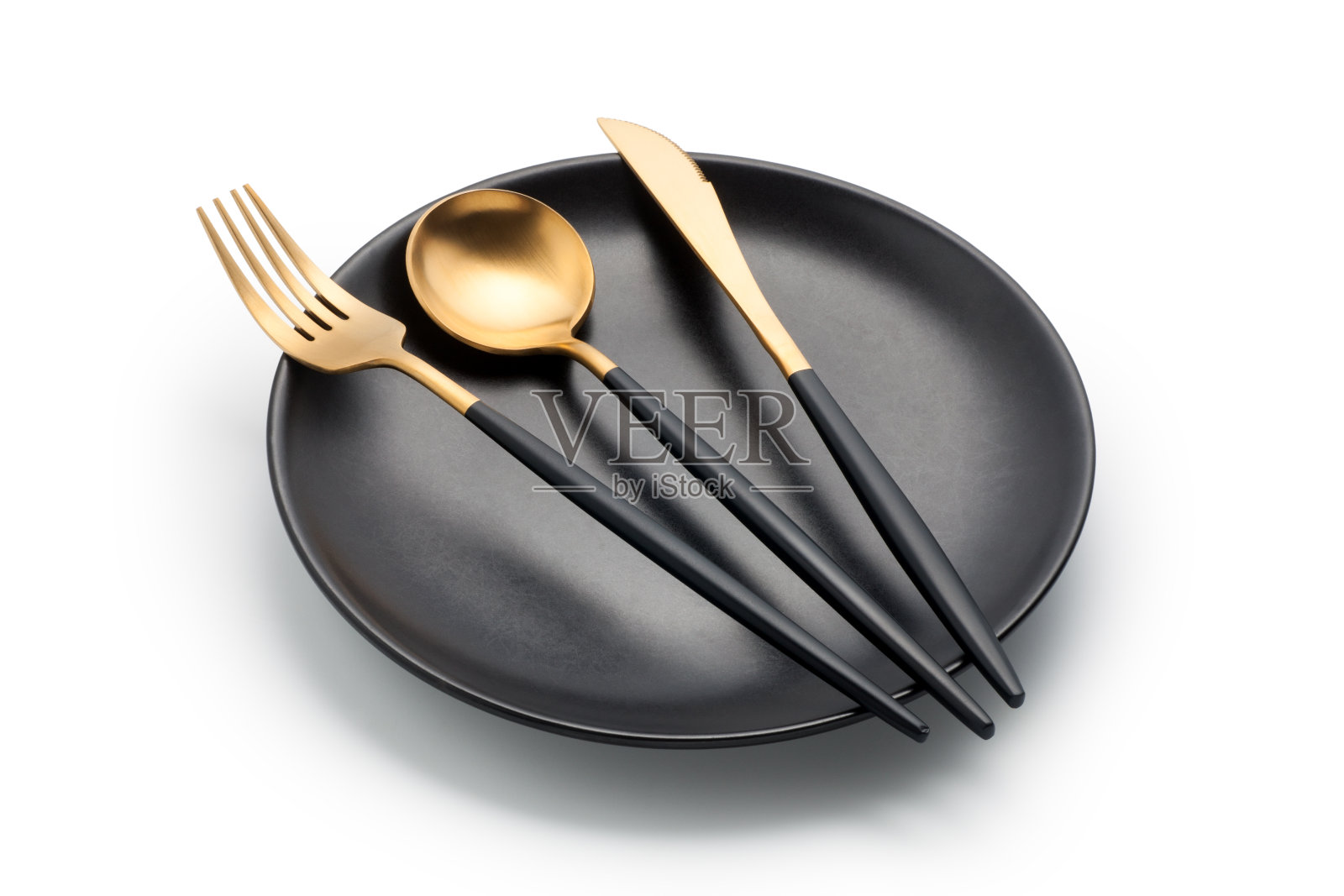 餐具，刀叉和勺子放在一个空的黑色盘子里照片摄影图片