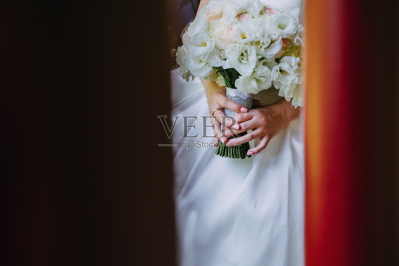 新娘手中美丽的白色花束，背景是时尚的婚纱照片摄影图片