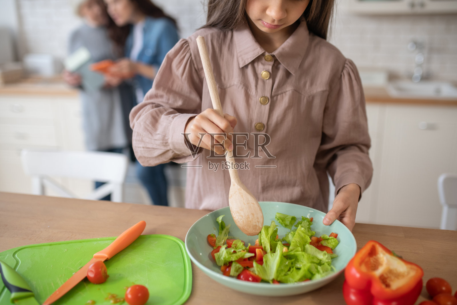 用勺子搅拌切碎的蔬菜沙拉。照片摄影图片