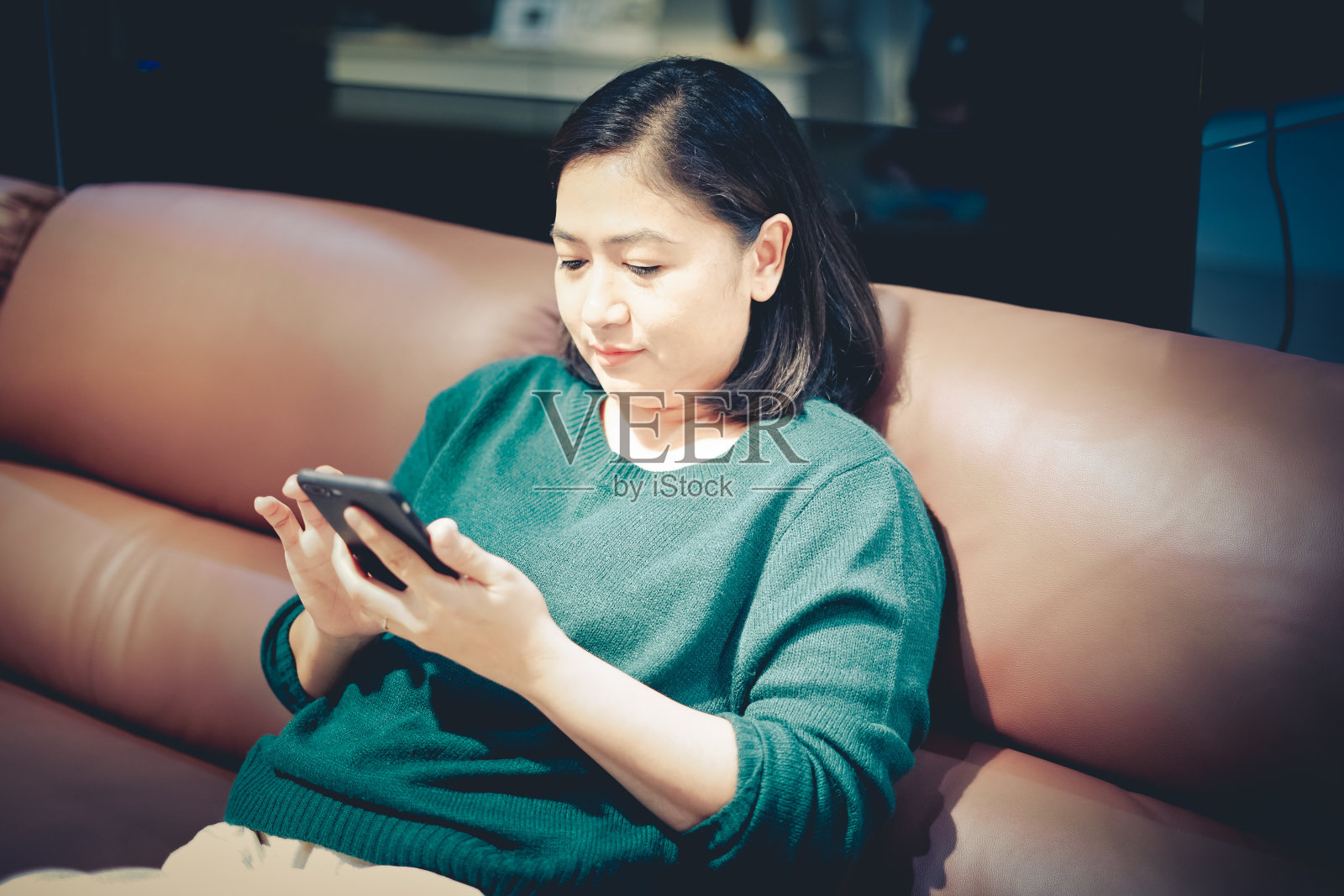 亚洲女性在沙发上使用手机照片摄影图片