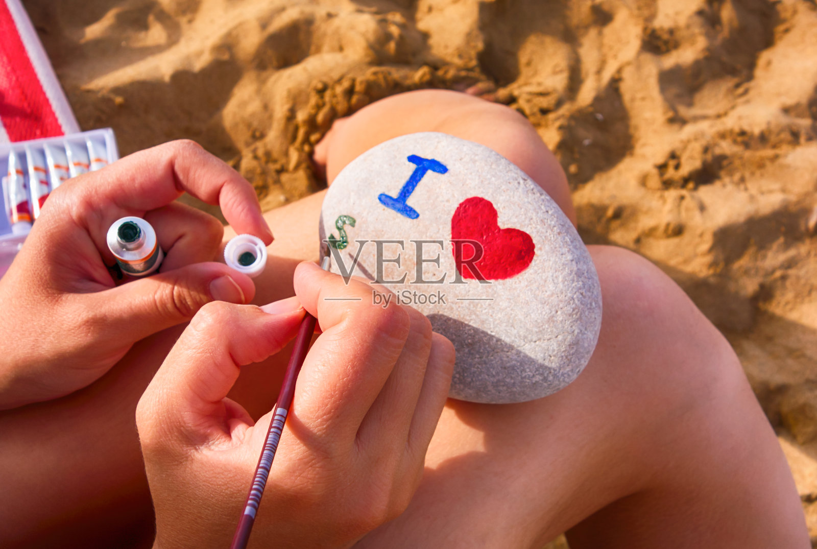 沙滩上的女人在卵石上画画-我的心，s。照片摄影图片
