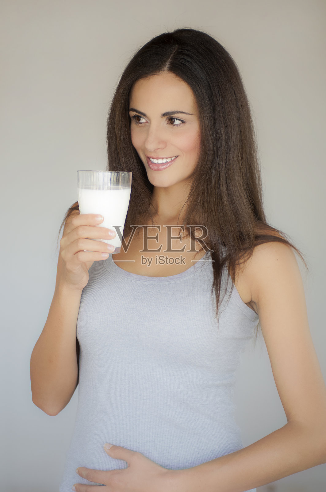 一个留着长发，手里拿着一杯牛奶的年轻女人的半身像照片摄影图片