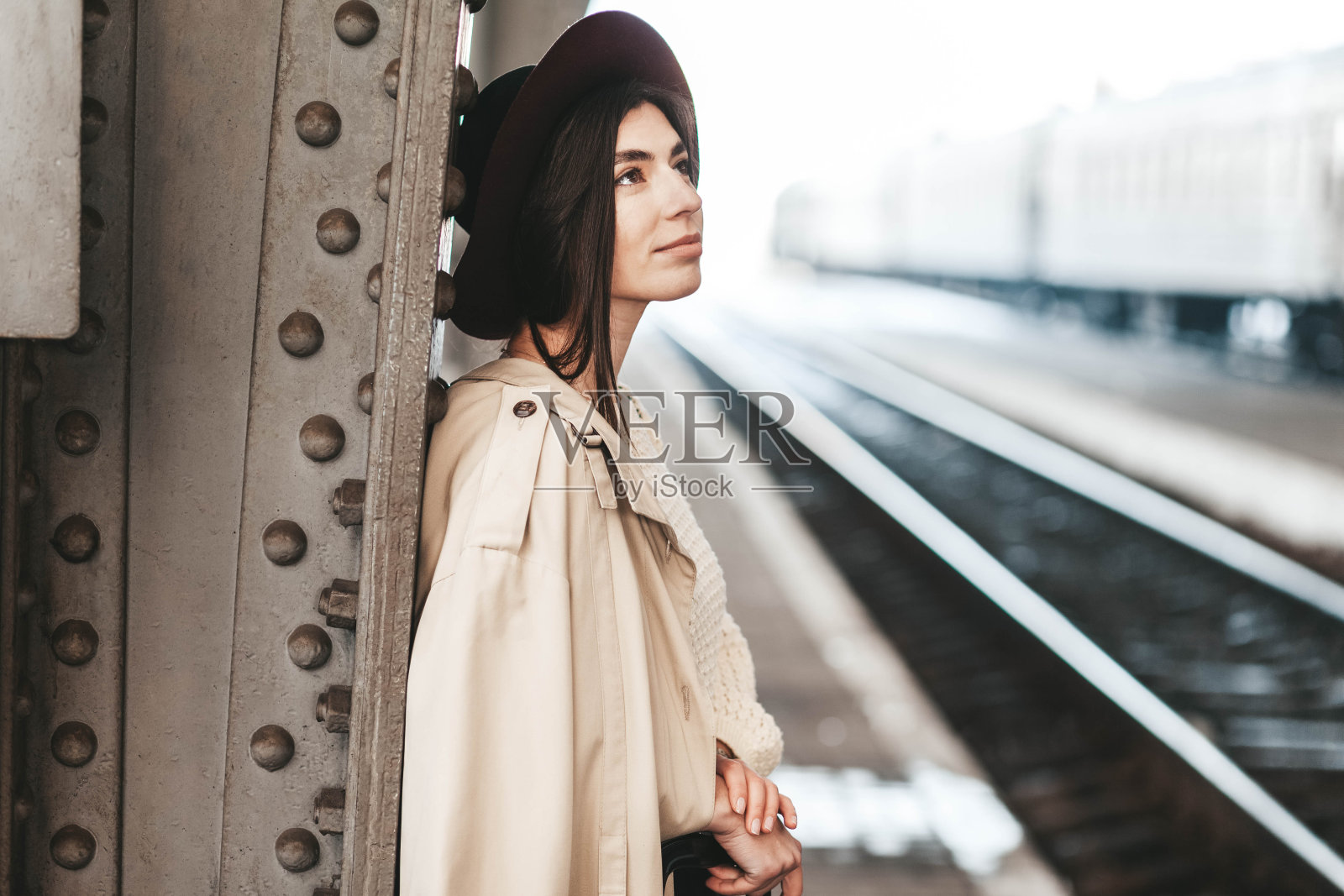 年轻美丽的女旅客的肖像，她正在火车站的月台上等火车照片摄影图片