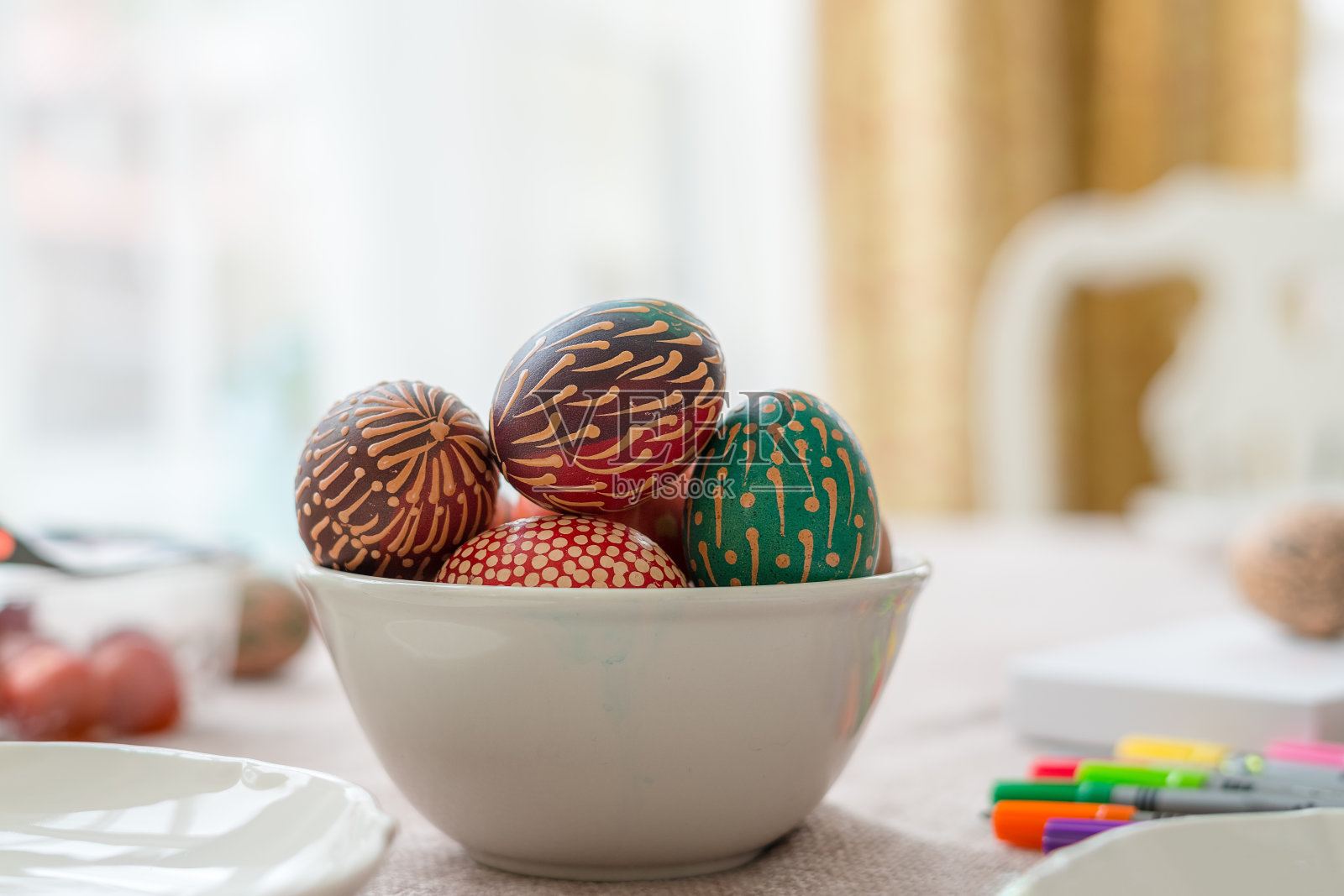 彩色的蜡画复活节彩蛋在碗木桌子上，蜡画的装饰品，彩虹花，点照片摄影图片