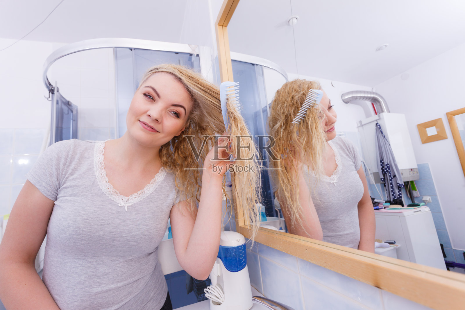 一个女人在浴室里梳理她的长发照片摄影图片