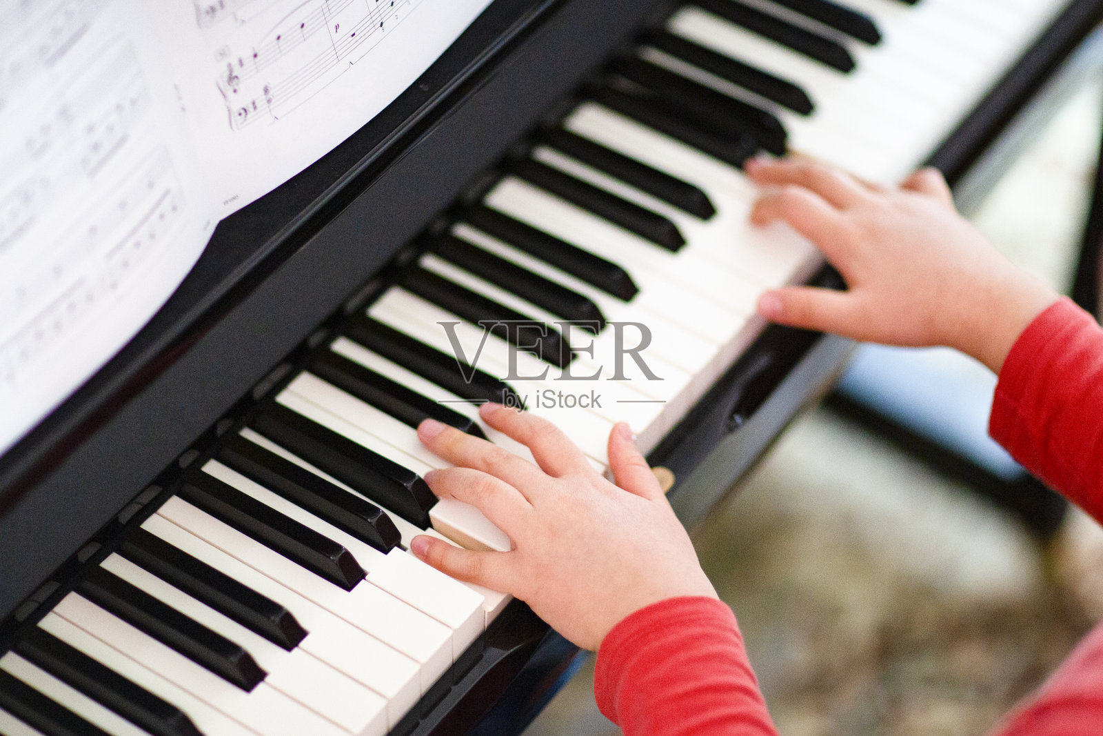合上男孩弹奏钢琴的手照片摄影图片
