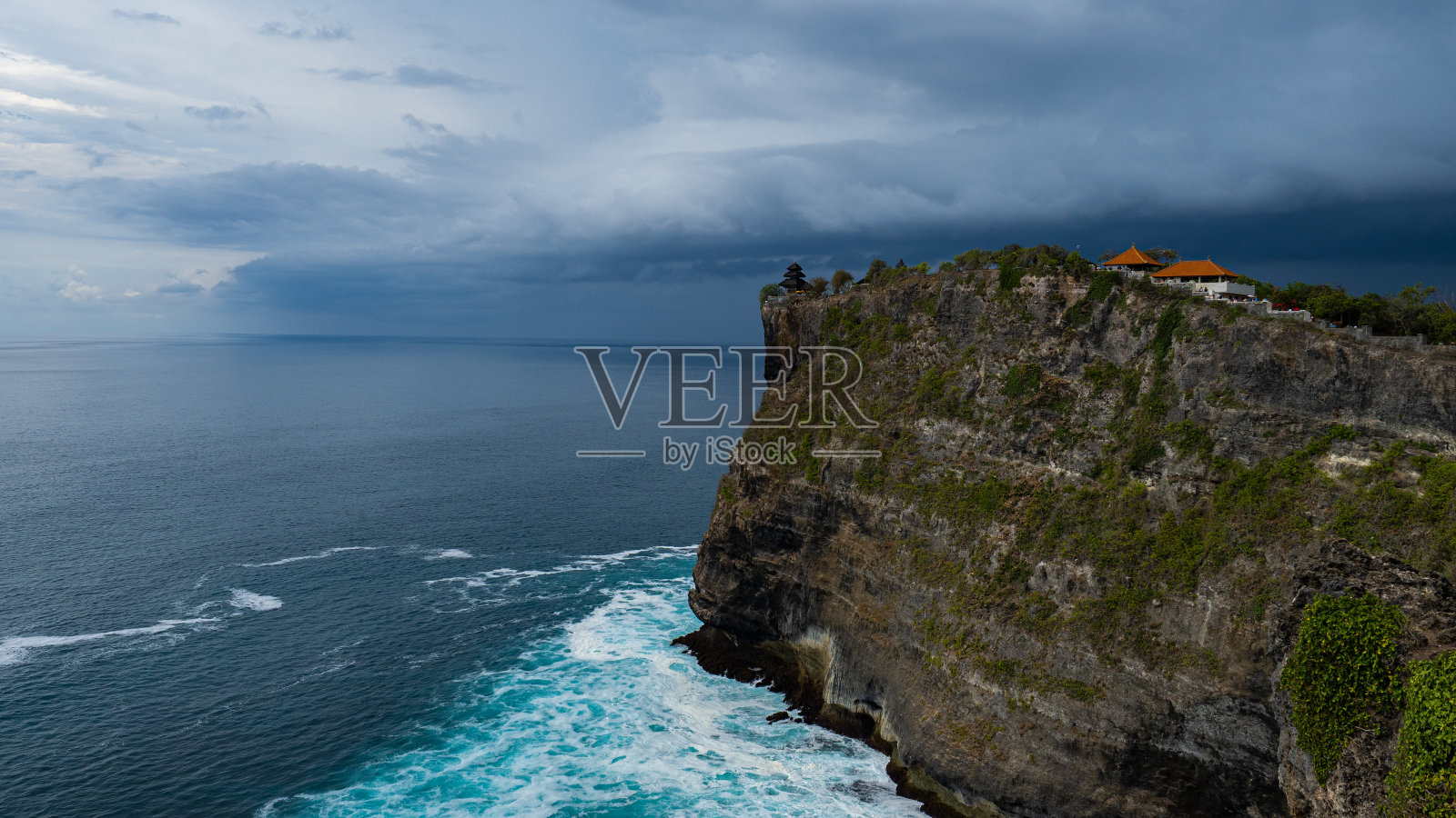 大雨前，印尼巴厘岛海岸线上的乌鲁瓦图寺庙悬崖景观照片摄影图片