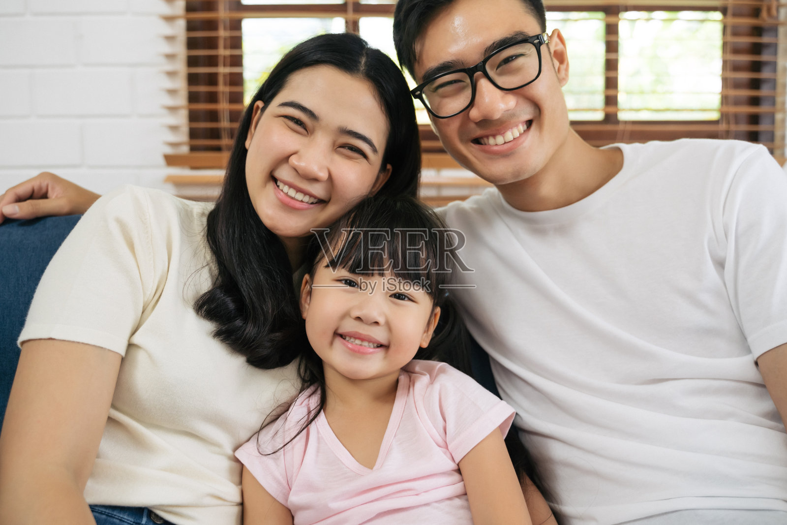 幸福的亚洲家庭花时间一起在客厅的沙发上的肖像。家庭和家庭的概念。照片摄影图片