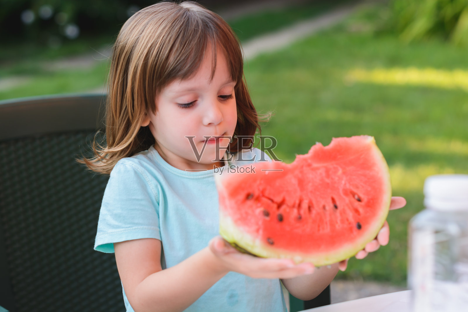 可爱的小女孩在吃西瓜。照片摄影图片