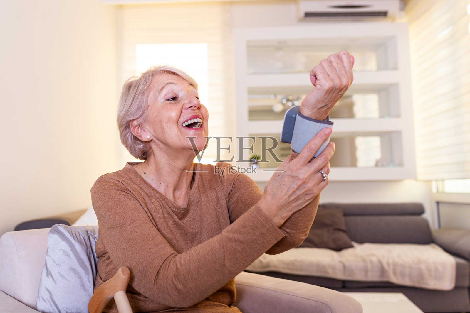 健康概念老年妇女用血压监测仪照顾健康。高血压。成熟女性在家测量血压照片摄影图片