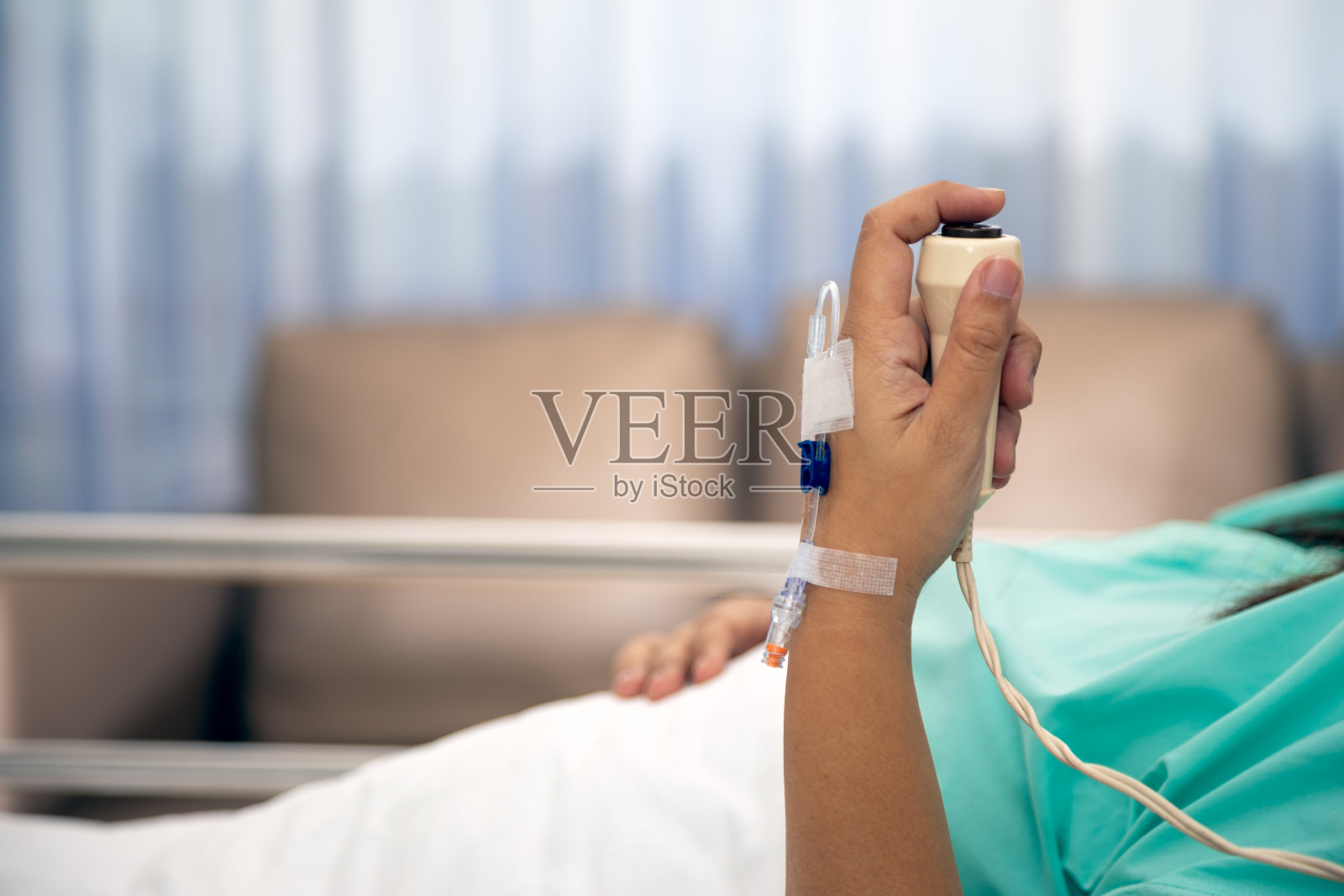 在医院病房里，妇女手握紧急按钮并按下按钮;紧急情况时用手按呼叫护士照片摄影图片