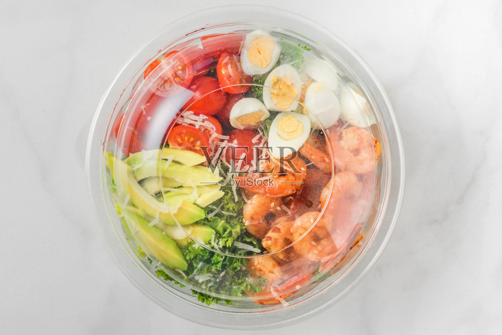 塑料包装的健康虾凯撒沙拉，鳄梨，羽衣甘蓝，西红柿和鸡蛋带走。地中海式饮食照片摄影图片