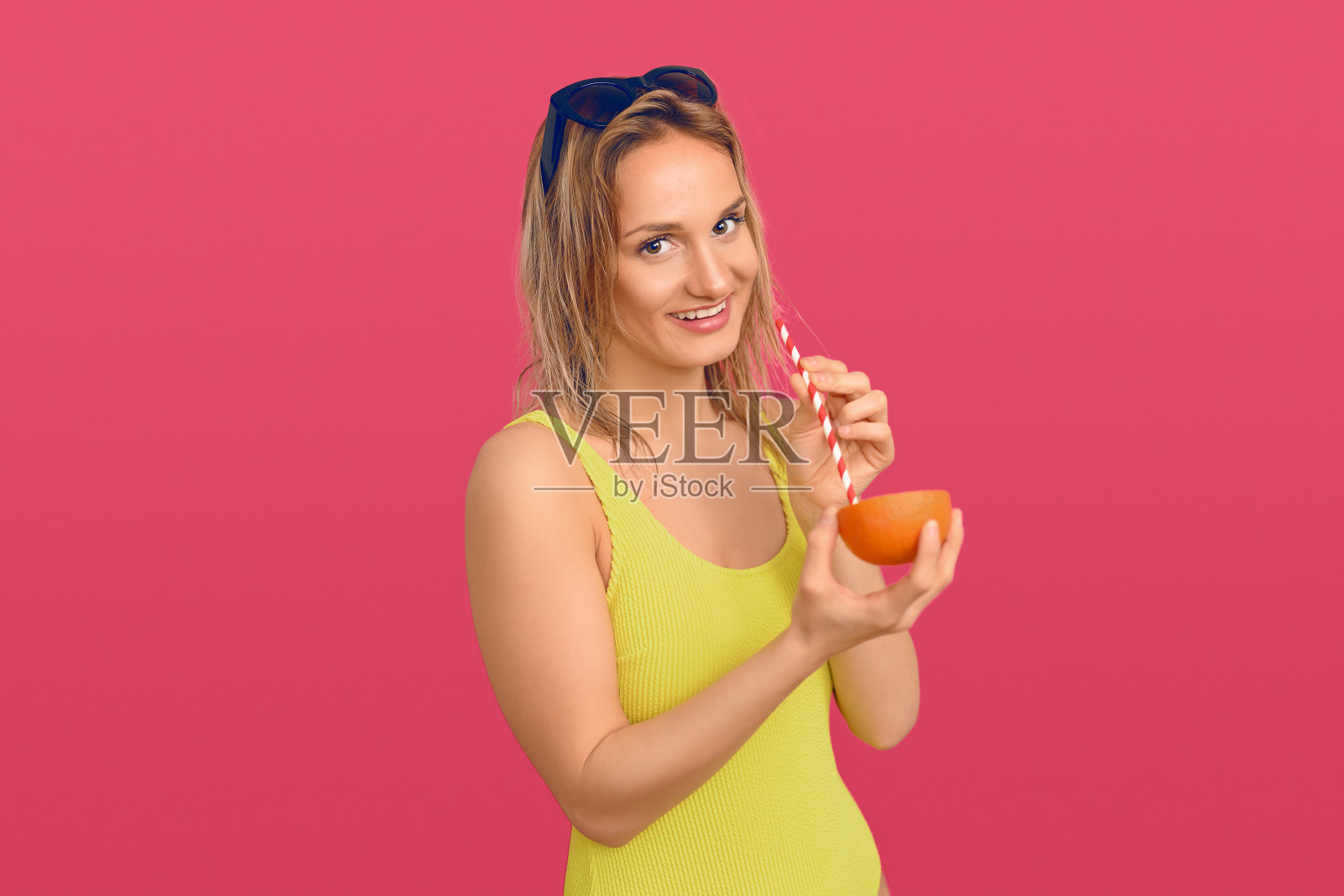 用吸管喝橘子的女人照片摄影图片