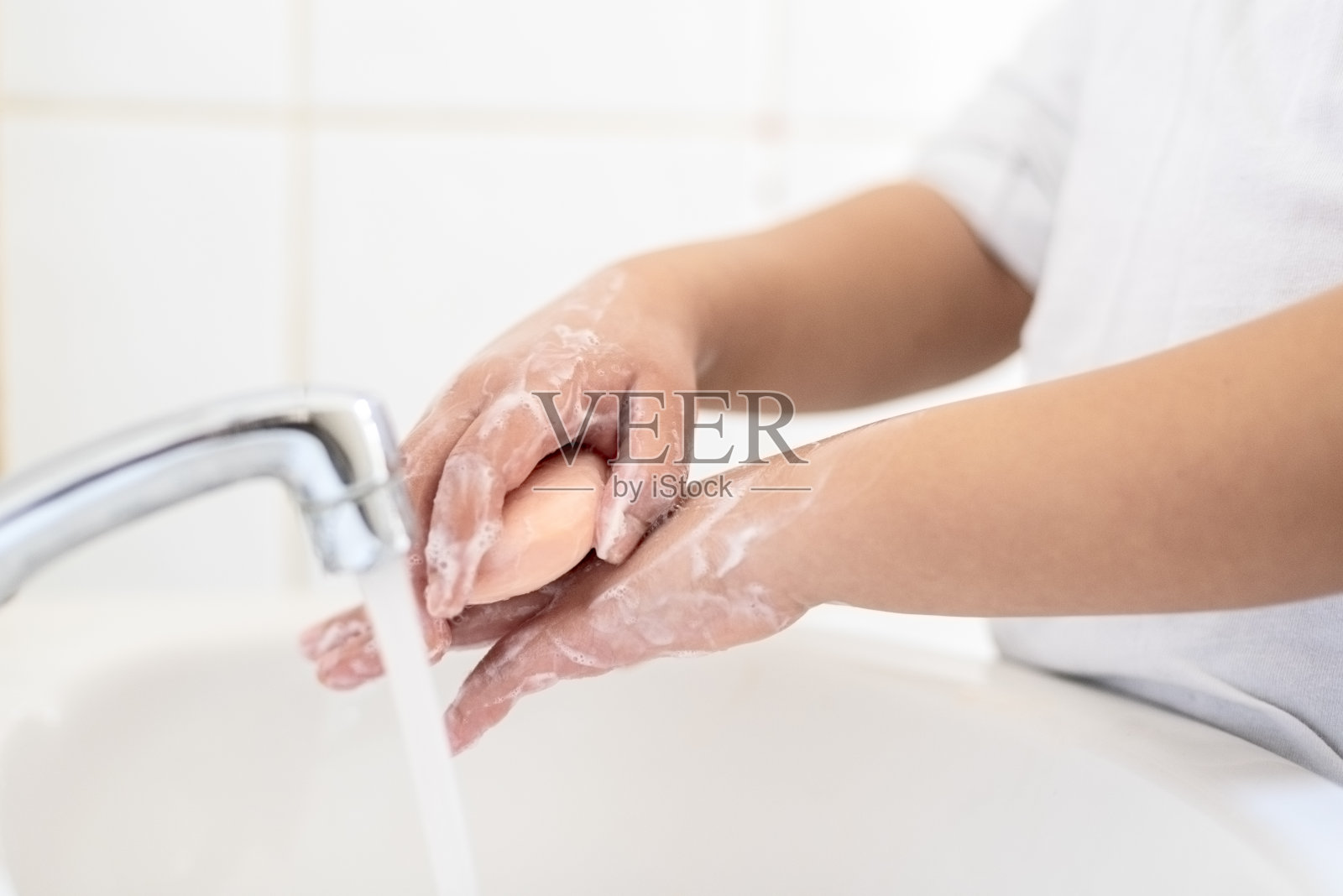 孩子(8-9)洗手。照片摄影图片